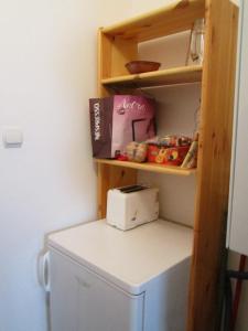 a white refrigerator in a kitchen with a shelf at Toldi Apartman in Budapest