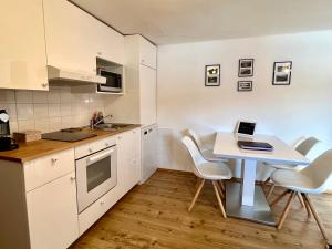 a kitchen with a white table and white chairs at Haus Thomas in Werfenweng +45 photos