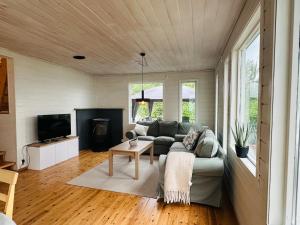 a living room with a couch and a tv at Look at this view! 3 BR house overlooking Hardangerfjorden in Kvam