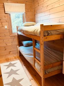 a bedroom with two bunk beds in a log cabin at Look at this view! 3 BR house overlooking Hardangerfjorden in Kvam