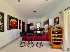 a kitchen with red cabinets and bar stools at Sunset bay view villa krabi in Ban Khao Thong