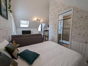 a bedroom with a bed and a living room at Le Studio Neo-Retro in Digoin