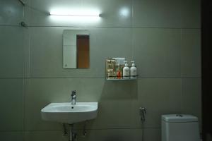 a bathroom with a sink and a toilet and a mirror at Abad Silver Mist in Vagamon