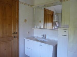 ein weißes Badezimmer mit einem Waschbecken und einem Spiegel in der Unterkunft L'orchidée in Rochehaut