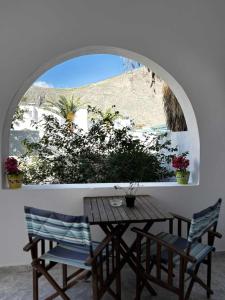 a table and chairs in a room with a window at BlackBeach village in Perissa +40 photos