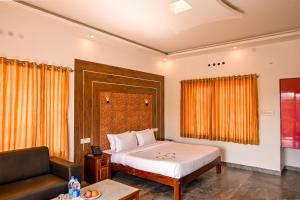 a bedroom with a bed and a couch at Abad Silver Mist in Vagamon