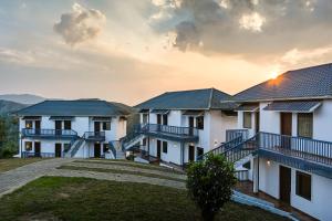 a row of houses with a sunset in the background at Abad Silver Mist in Vagamon +16 photos