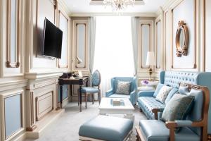 a living room with blue furniture and a tv at d'Primahotel Bandung in Bandung