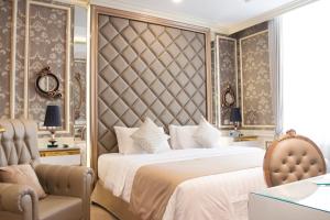 a bedroom with a large bed and a chair at d'Primahotel Bandung in Bandung +30 photos