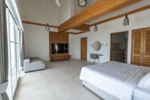 a bedroom with a large bed and a television at Nalas Villa in Ketewel