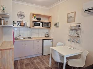 a small kitchen with a table and a table and chairs at Number 4 Smugglers Inn in Victor Harbor
