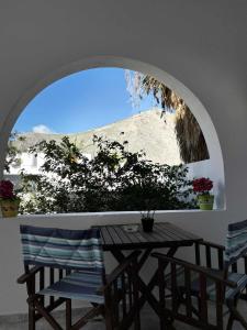 a table and chairs in a room with a window at BlackBeach village in Perissa