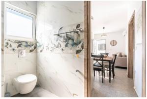a bathroom with a toilet and a dining room at Restaurant Maria Suites SunSet in Faliraki +8 photos