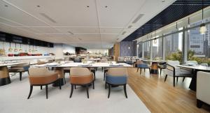 a dining room with tables and chairs in a restaurant at Novotel Chengdu Lige in Chengdu