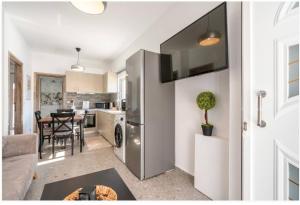 a kitchen with a stainless steel refrigerator and a table at Restaurant Maria Suites SunSet in Faliraki