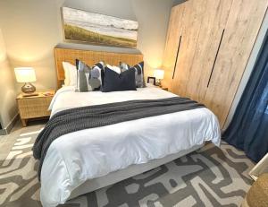 a bedroom with a large bed with black and white pillows at IBella's at The Urban in Pretoria
