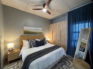 a bedroom with a large bed with a ceiling fan at IBella's at The Urban in Pretoria +36 photos