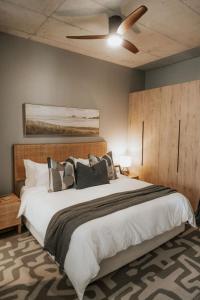 a bedroom with a large bed with a ceiling fan at IBella's at The Urban in Pretoria