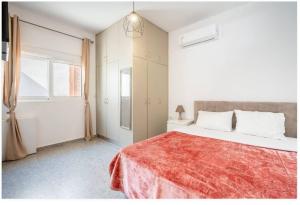 a white bedroom with a large bed with a red blanket at Restaurant Maria Suites SunSet in Faliraki