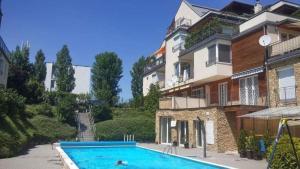 a swimming pool in front of a building at Koczor Apartman in Balatonfüred