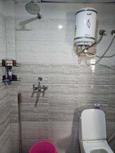 a bathroom with a toilet and a bucket on the wall at the varun residency in Greater Noida +22 photos