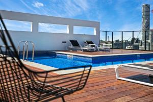 a deck with a chair and a pool on a building at Soda Apartments by CLLIX in Brisbane