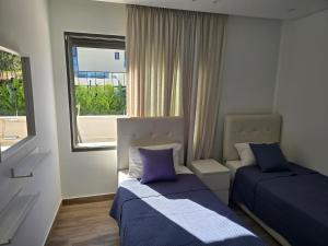 a small bedroom with two beds and a window at Villa rooftop with stunning view apartment in Amman