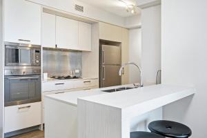 a kitchen with a refrigerator, stove, sink and microwave at Soda Apartments in Brisbane