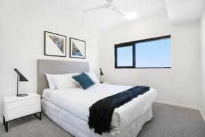a white bedroom with a large bed and a window at Soda Apartments by CLLIX in Brisbane +61 photos