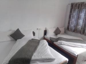 two beds sitting next to each other in a room at Hotel Amit Kedar Dham in Sirsi