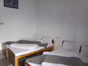 two twin beds in a room withthritisthritisthritisthritisthritisthritisthritisthritisthritis at Hotel Amit Kedar Dham in Sirsi