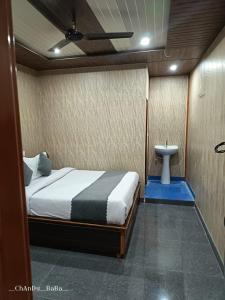 a bedroom with a bed and a sink in it at Hotel Amit Kedar Dham in Sirsi