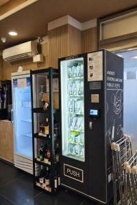 a black refrigerator in a store with drinks in it at Haeundae HaeRium Hotel in Busan