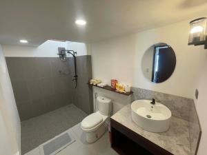 a bathroom with a sink and a toilet and a mirror at Alfa Beachfront Lofts in El Nido +38 photos