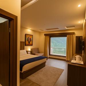 a hotel room with a bed and a large window at The Summerlead, Shimla in Shimla