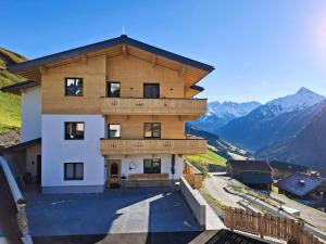 a large wooden building with mountains in the background at Himmenhof in Tux