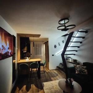 a living room with a spiral staircase and a table at Holiday house Aria Vučedol in Vukovar