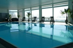 a large swimming pool with chairs in a building at Sofias Alpenpanorama inkl Aktivcard Bayerischer Wald in Freyung