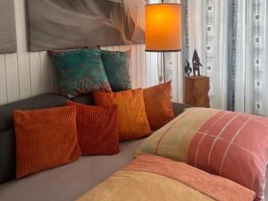 a couch with a bunch of pillows on it at Sofias Alpenpanorama inkl Aktivcard Bayerischer Wald in Freyung +28 photos