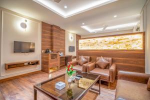 a living room with a couch and a tv at Hotel Varun in Guna