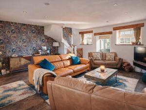 a living room with a couch and a table at Pastures Barn in Leek