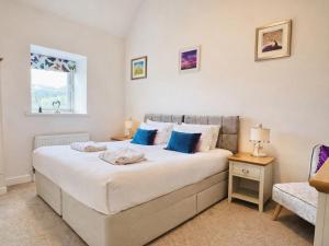 a bedroom with a large bed and a chair at Pastures Barn in Leek