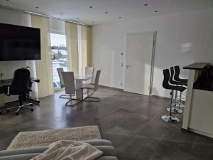 a living room with a couch and a table and chairs at Brenzapartments Heidenheim in Heidenheim an der Brenz +3 photos