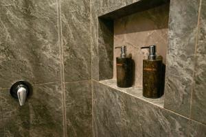 two bottles ofodorizers on a wall in a bathroom at Sandat Garden House in Ubud +85 photos