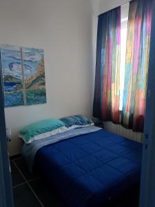 a bedroom with a blue bed with a window at TCEM camera in attico 6 no ascensore in Piombino