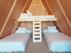 two bunk beds in a tent with white pillows at Camping Costa da Morte in Zas