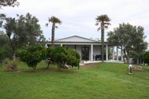 a house with palm trees in front of a yard at Blue Horizon in Sevastí