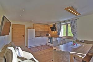 a kitchen and dining room with a table and a refrigerator at Himmenhof in Tux