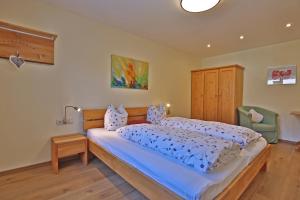a bedroom with a large bed and a chair at Himmenhof in Tux