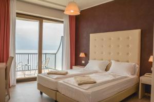 a bedroom with a large bed and a balcony at HOTEL ASTOR in Limone sul Garda +83 photos